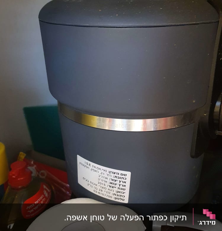 מכשיר טוחן אשפה מתחת לכיור עם צינורות וחיבורים